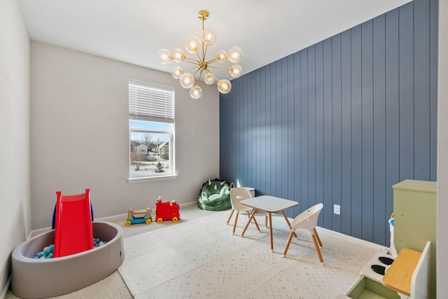 game room with a chandelier and baseboards