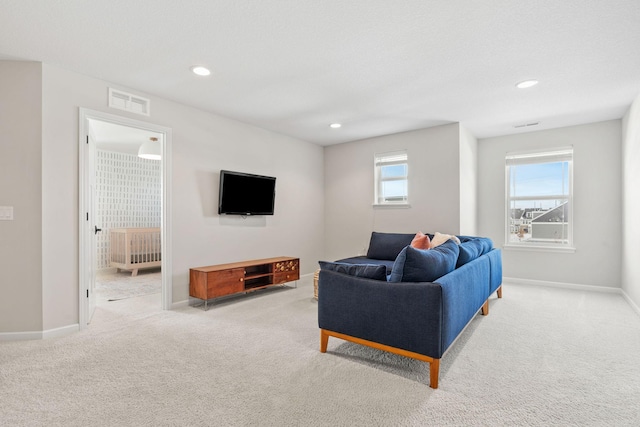 carpeted living area featuring visible vents, recessed lighting, and baseboards