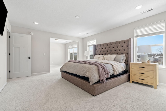 bedroom with recessed lighting, visible vents, baseboards, and light colored carpet