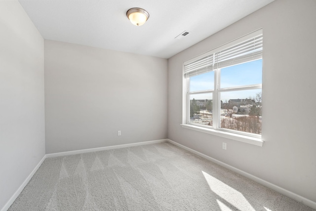 unfurnished room featuring carpet flooring, visible vents, and baseboards