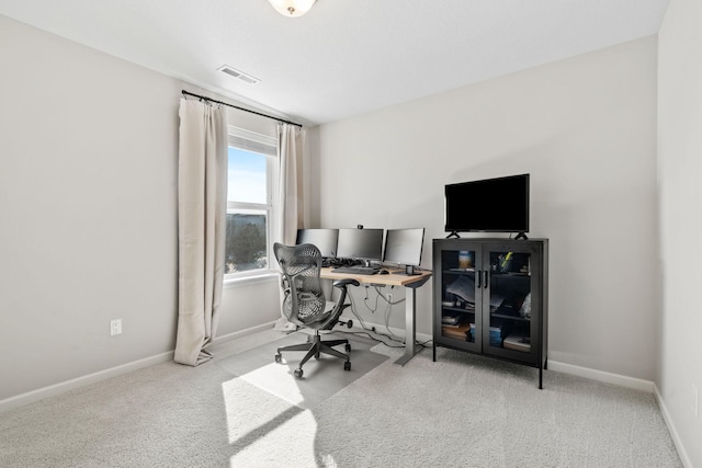 carpeted home office featuring visible vents and baseboards