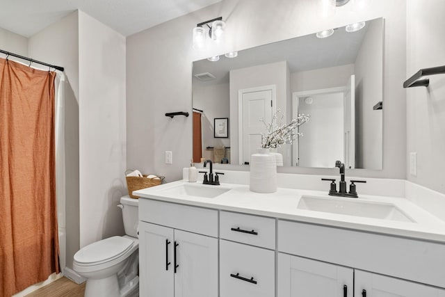 full bathroom featuring double vanity, toilet, visible vents, and a sink