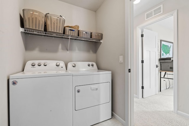 clothes washing area featuring baseboards, visible vents, washing machine and clothes dryer, laundry area, and light carpet