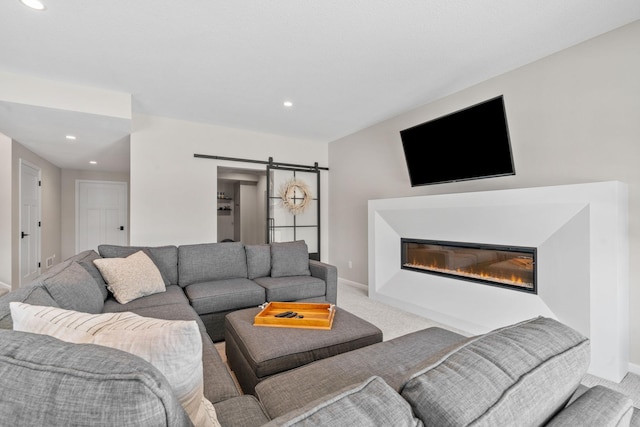 living area with baseboards, a barn door, carpet flooring, recessed lighting, and a glass covered fireplace