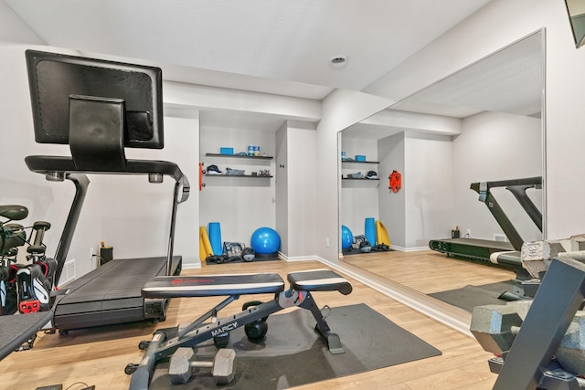 exercise room with baseboards and wood finished floors