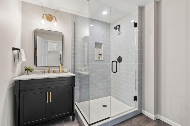 bathroom with recessed lighting, a stall shower, vanity, and baseboards