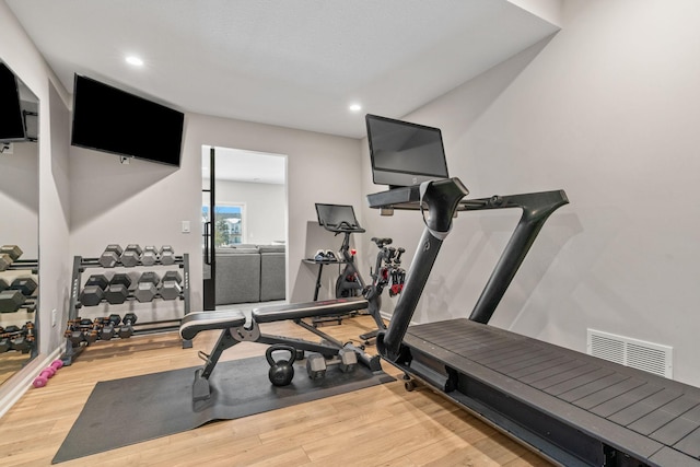 workout area featuring recessed lighting, wood finished floors, and visible vents