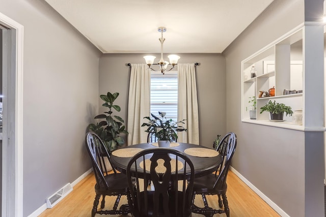 dining area featuring light hardwood / wood-style floors and an inviting chandelier