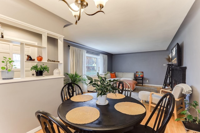 dining space featuring an inviting chandelier and light wood-type flooring