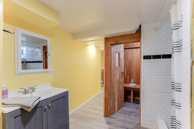 bathroom featuring vanity, wood-type flooring, and walk in shower