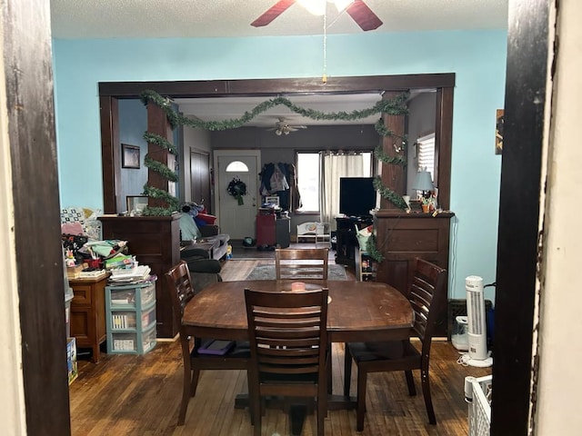 dining room featuring ceiling fan, dark wood-type flooring, and a textured ceiling