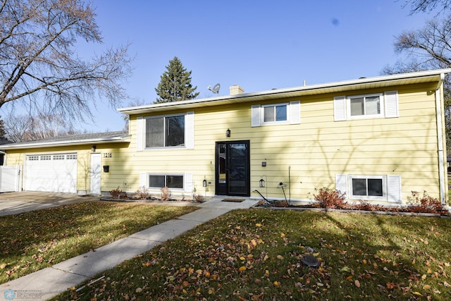 bi-level home featuring a garage and a front lawn