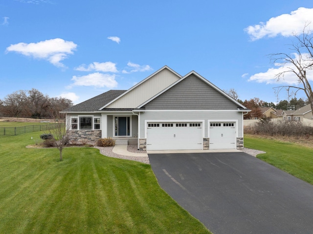 view of front of property with an attached garage, stone siding, aphalt driveway, and a front yard