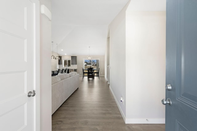 corridor featuring baseboards and wood finished floors