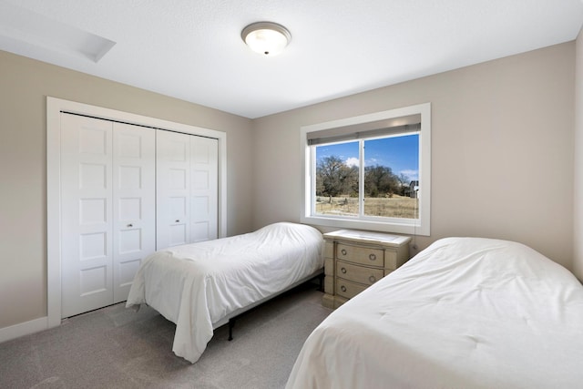 carpeted bedroom featuring a closet and baseboards