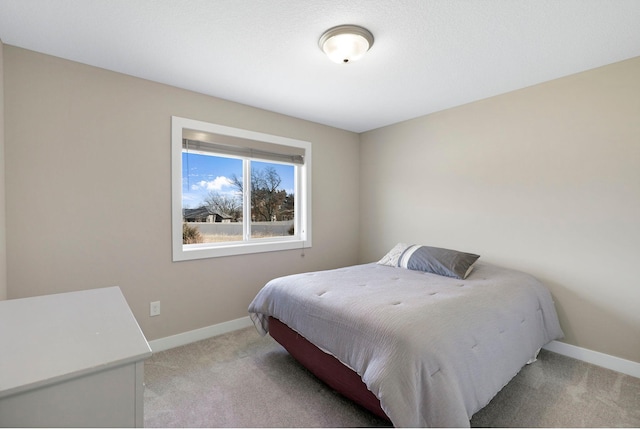 bedroom featuring light colored carpet and baseboards