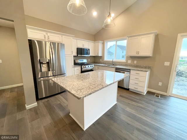 kitchen with white cabinetry, appliances with stainless steel finishes, hanging light fixtures, and a kitchen island