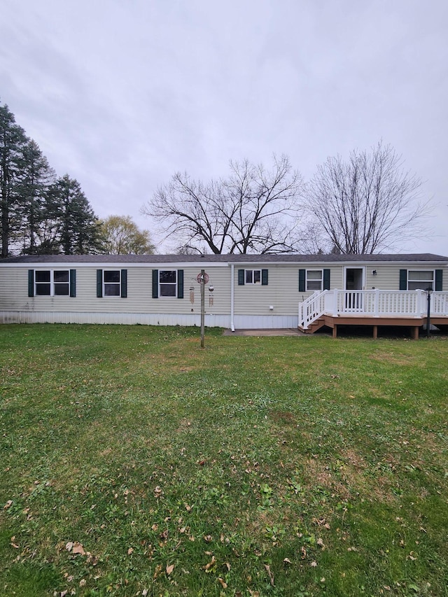 view of front of home with a deck and a front lawn