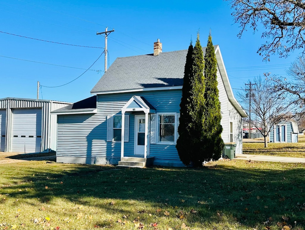 view of front of home with an outbuilding, a garage, and a front lawn