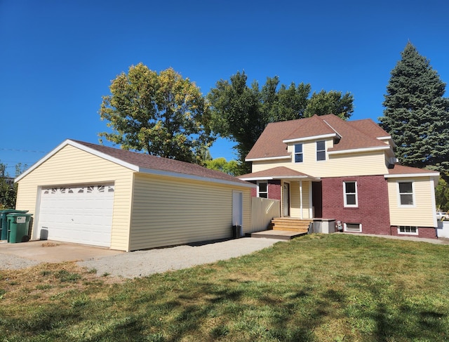 front facade featuring cooling unit, a front yard, and a garage