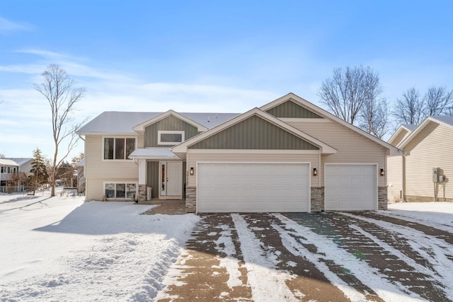 view of front of house with concrete driveway, an attached garage, and stone siding