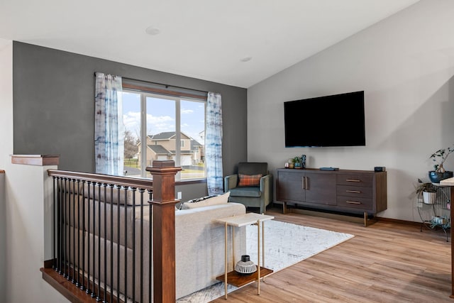 living room featuring baseboards, lofted ceiling, and wood finished floors