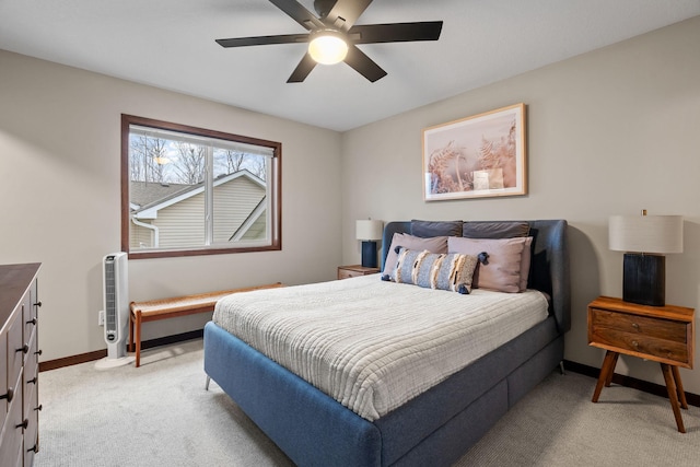 bedroom with light colored carpet, a ceiling fan, and baseboards