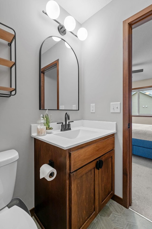 bathroom featuring ensuite bathroom, toilet, vanity, and baseboards