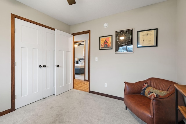 sitting room with carpet flooring, a ceiling fan, and baseboards