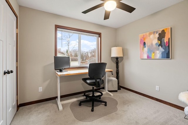 home office featuring light carpet, baseboards, and a ceiling fan