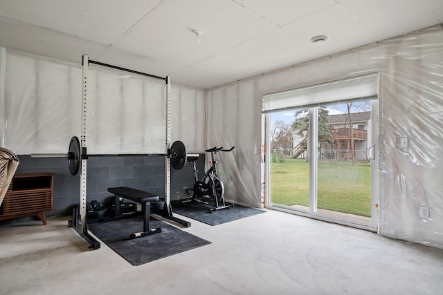 exercise room featuring concrete block wall