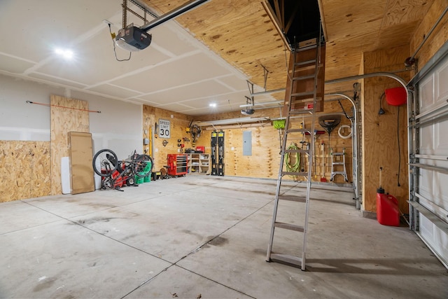 garage with electric panel, a workshop area, and a garage door opener