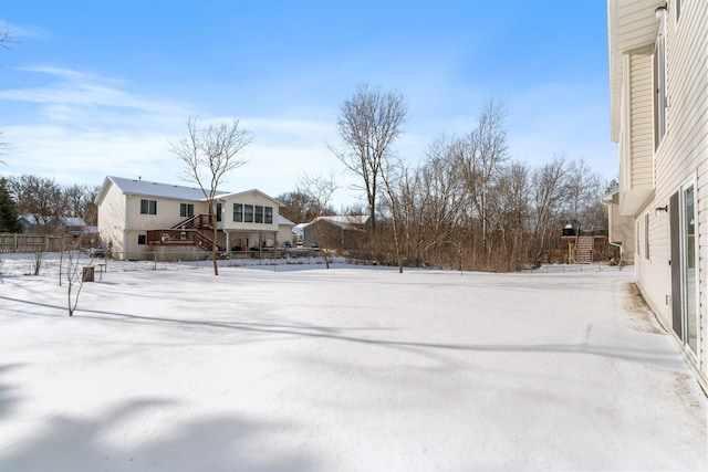 yard covered in snow featuring stairway and fence