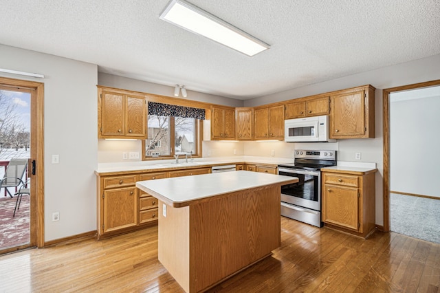 kitchen featuring a center island, sink, white appliances, and a textured ceiling