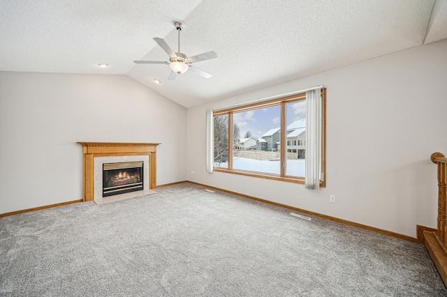 unfurnished living room with carpet, ceiling fan, lofted ceiling, and a high end fireplace