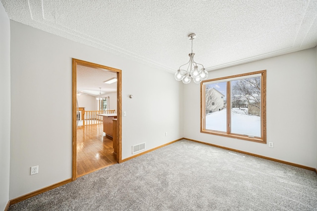 empty room with carpet flooring, a notable chandelier, and plenty of natural light