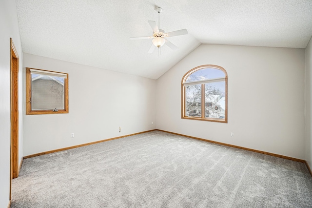 spare room with carpet flooring, ceiling fan, lofted ceiling, and a textured ceiling