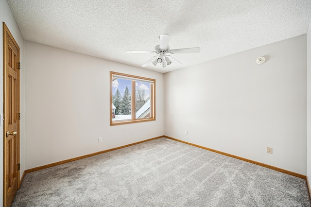 carpeted spare room with a textured ceiling and ceiling fan