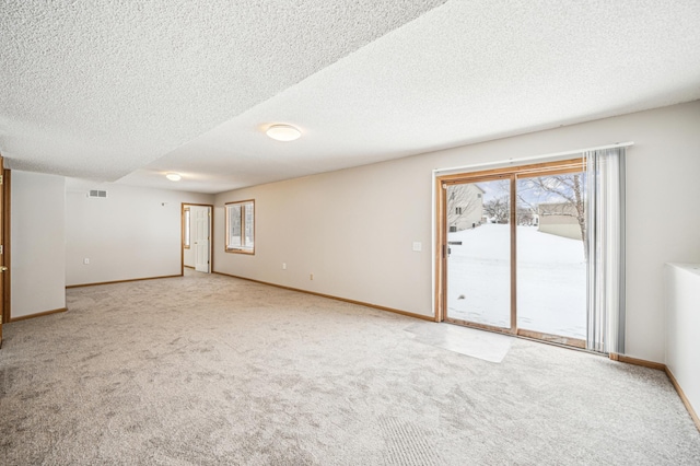 carpeted spare room with a textured ceiling