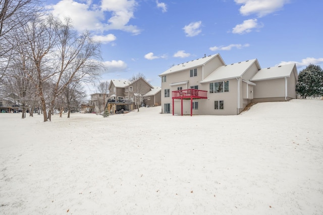 snow covered back of property featuring a wooden deck