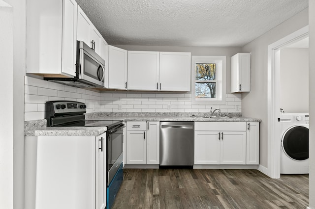 kitchen featuring white cabinetry, sink, stainless steel appliances, dark hardwood / wood-style flooring, and washer / dryer