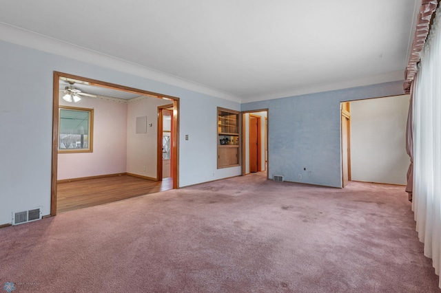 spare room featuring carpet floors, ceiling fan, and crown molding