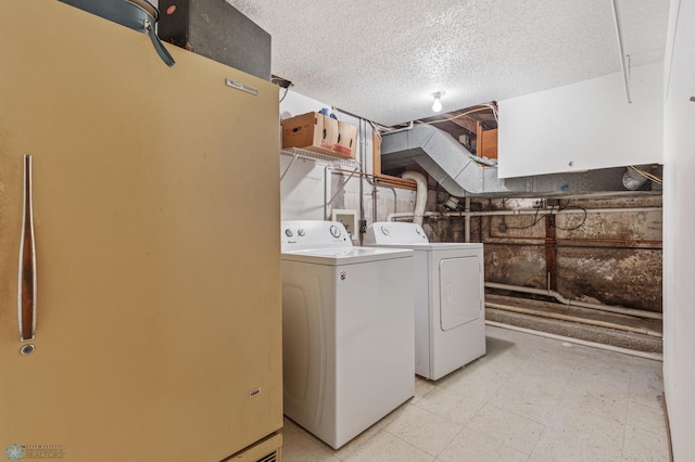 laundry room with washing machine and dryer and a textured ceiling