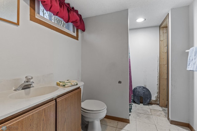 bathroom with tile patterned flooring, a textured ceiling, vanity, and toilet