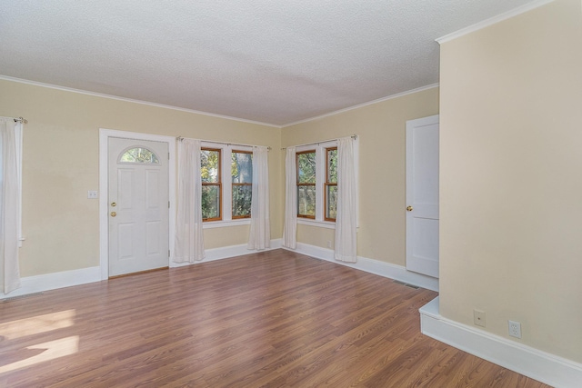 interior space featuring crown molding, wood-type flooring, and a textured ceiling