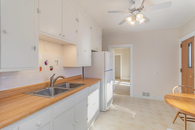 kitchen featuring white cabinetry, sink, and tasteful backsplash