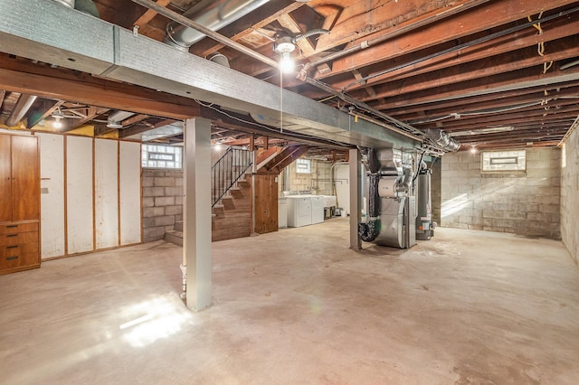 basement with gas water heater, independent washer and dryer, and heating unit