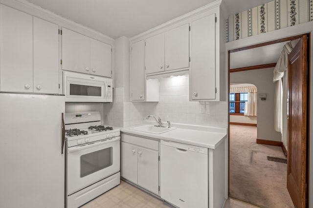 kitchen featuring white cabinetry, sink, light carpet, and white appliances