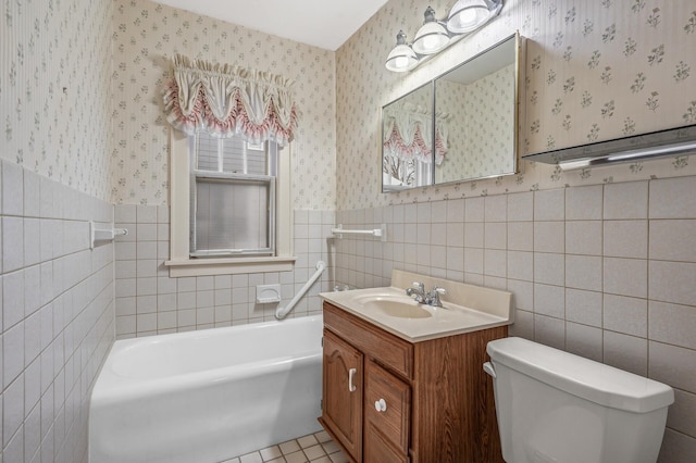 bathroom featuring a tub, vanity, tile walls, and toilet