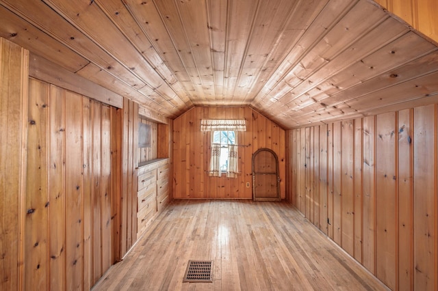 bonus room featuring wood walls, light hardwood / wood-style flooring, wooden ceiling, and vaulted ceiling